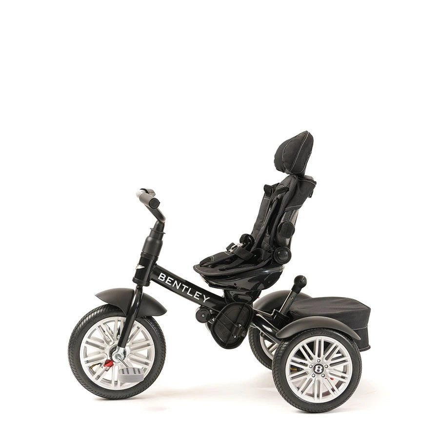 Bentley Trike 6‑in‑1 V2 Onyx Black: child sits in adjustable harnessed seat on a black three‑wheel tricycle.