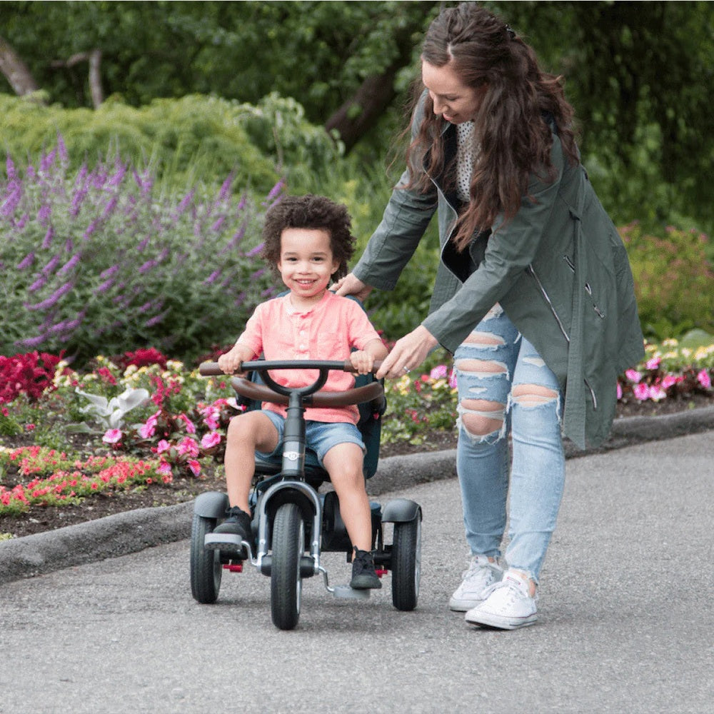 Bentley Trike 6-In-1 V2 Spruce Green, toddler ride-on with caregiver assistance outdoors