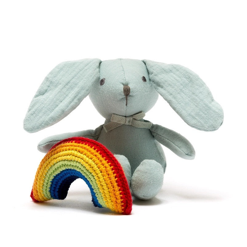 Best Years cotton bunny plush in teal with beige bow, shown beside a rainbow crochet arc
