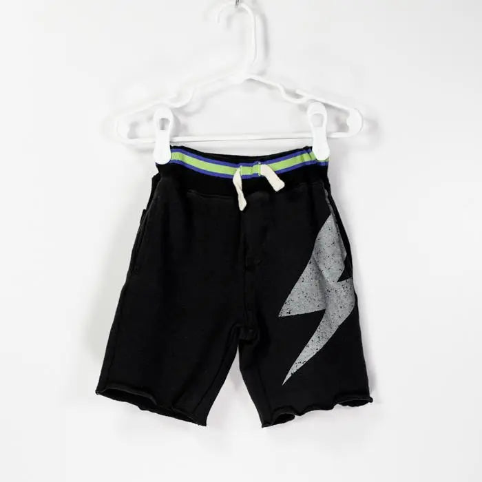 BIT'Z KIDS Lightning Printed Shorts on a hanger, black fabric with neon blue-green waistband and white drawstring