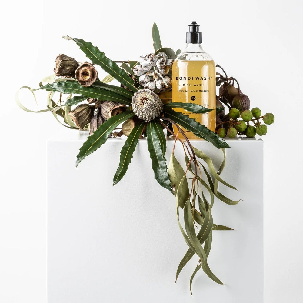 Bondi Wash dish wash 500 ml bottle with lemon tea tree and mandarin scent; yellow liquid beside greenery