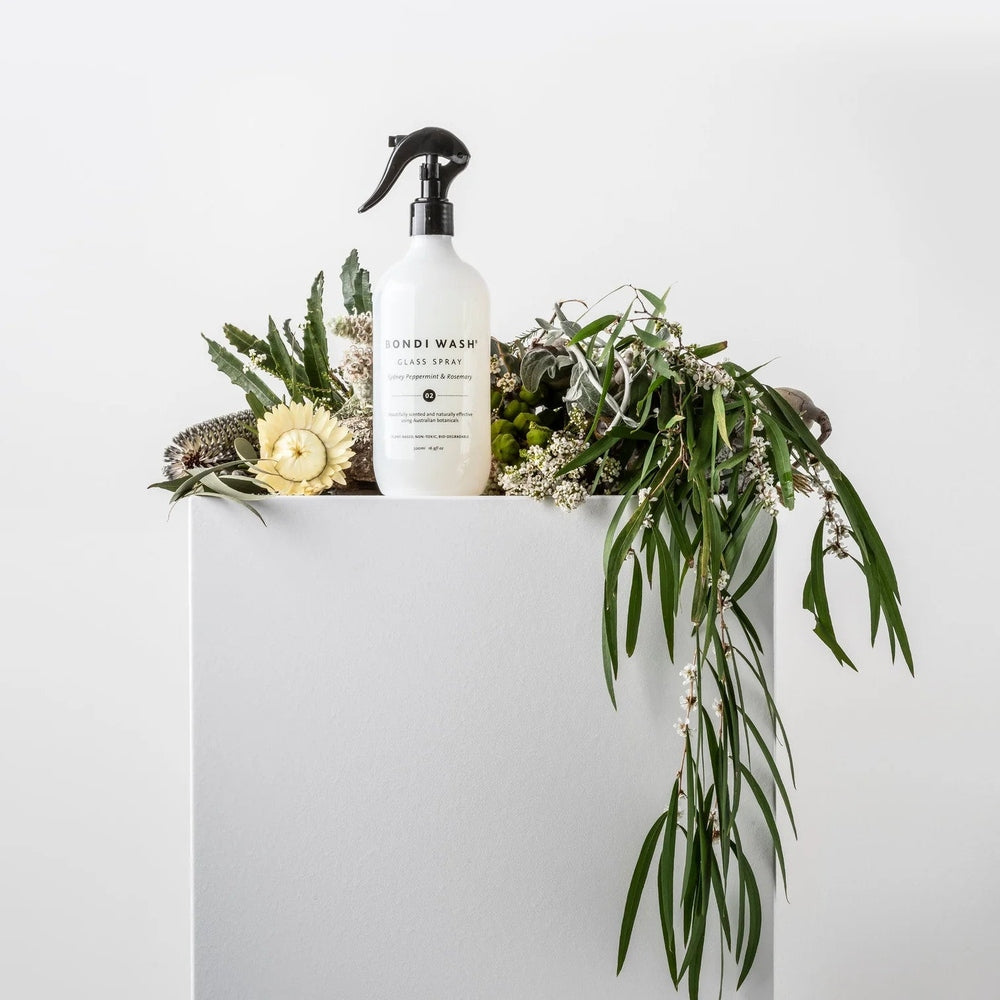 Bondi Wash Glass Spray Sydney Peppermint & Rosemary 500 ml bottle with greenery on a white pedestal