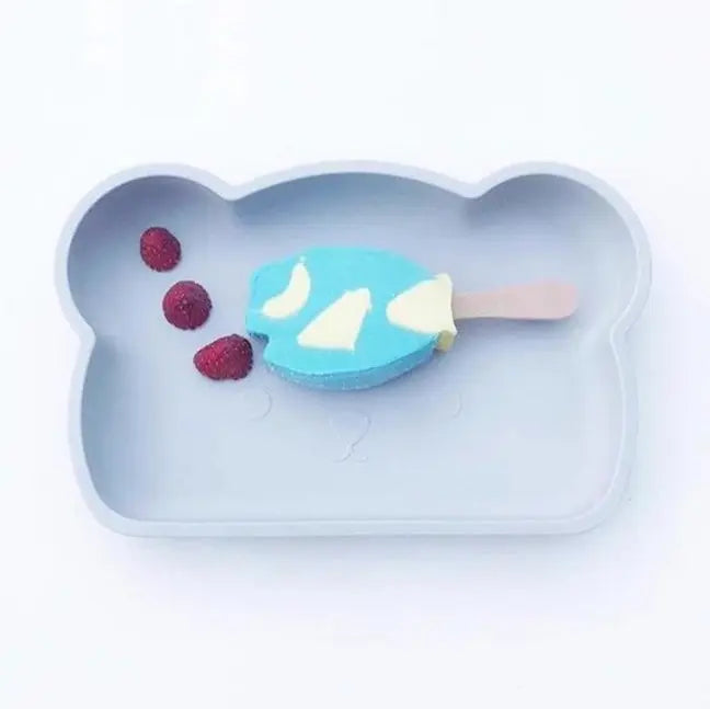 BOPOMOFO Bear Silicone Plate, blue bear-shaped plate with pink handle, raspberries sit nearby for mealtime.
