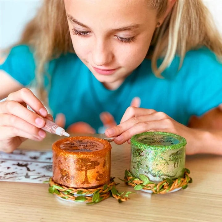 Box Candiy Totally Twilight glitter candles in orange and green jars with braided bases; girl crafting.