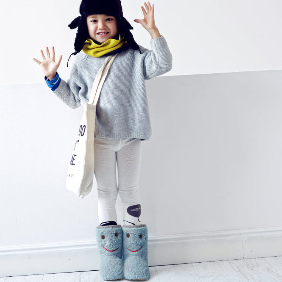 BOXBO Warm Winter Boots Ice Blue Bear; toddler stands smiling, showing off cute ice-blue fuzzy boots with bear faces.