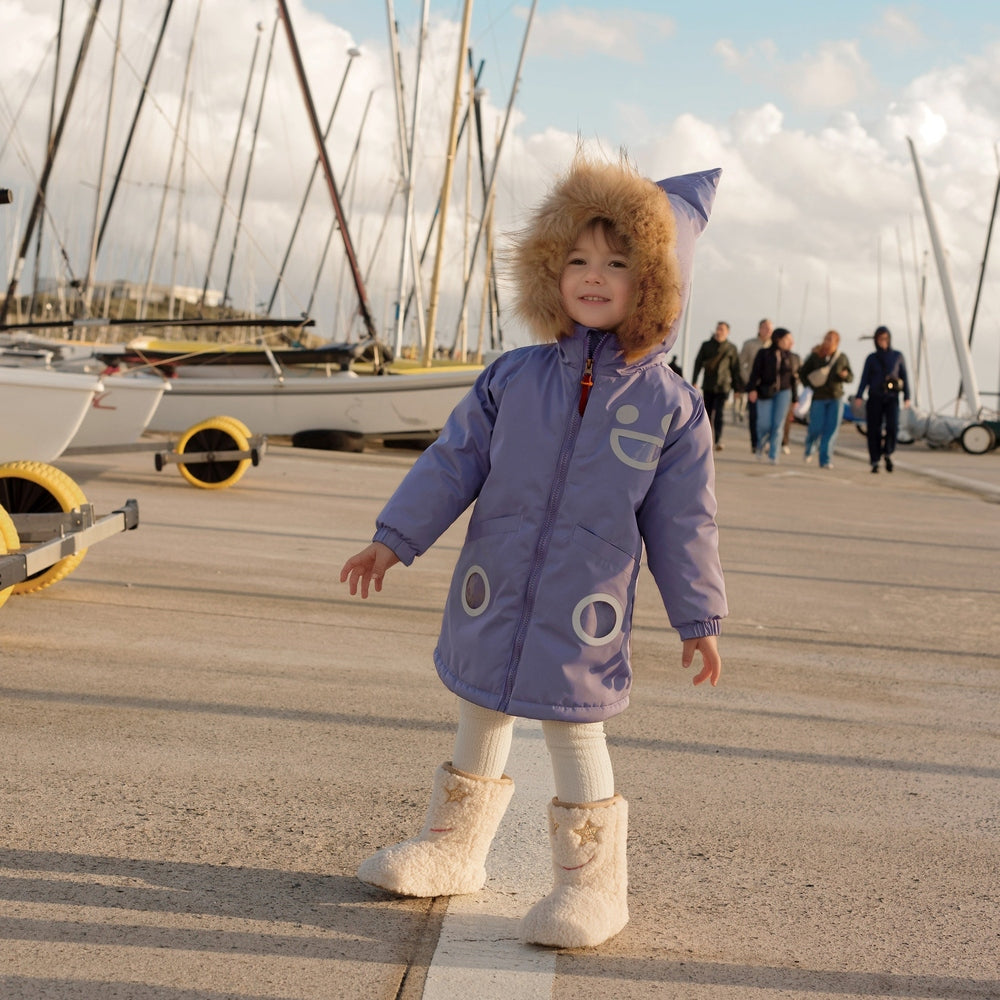 Boxbo Wistiti Fleece Lined Waterproof & Snowproof Fur Jacket Mauve Lavender worn by a child on a marina dock with fur-hood.