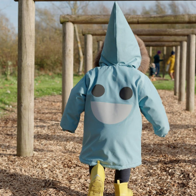 Boxbo Wistiti blue fleece-lined waterproof and snowproof fur jacket; toddler walks under wooden arches in a park.