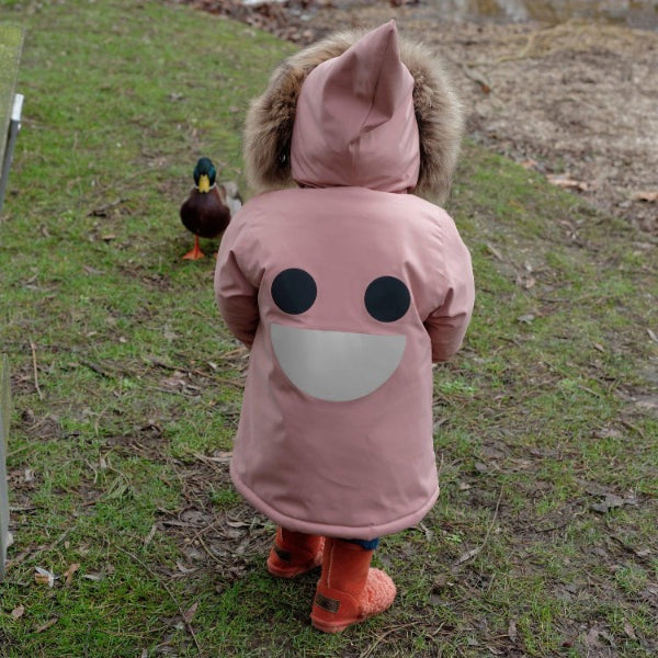 Boxbo Wistiti fleece-lined waterproof fur jacket in dusty rose pink with fur-trim hood, toddler walking outdoors.