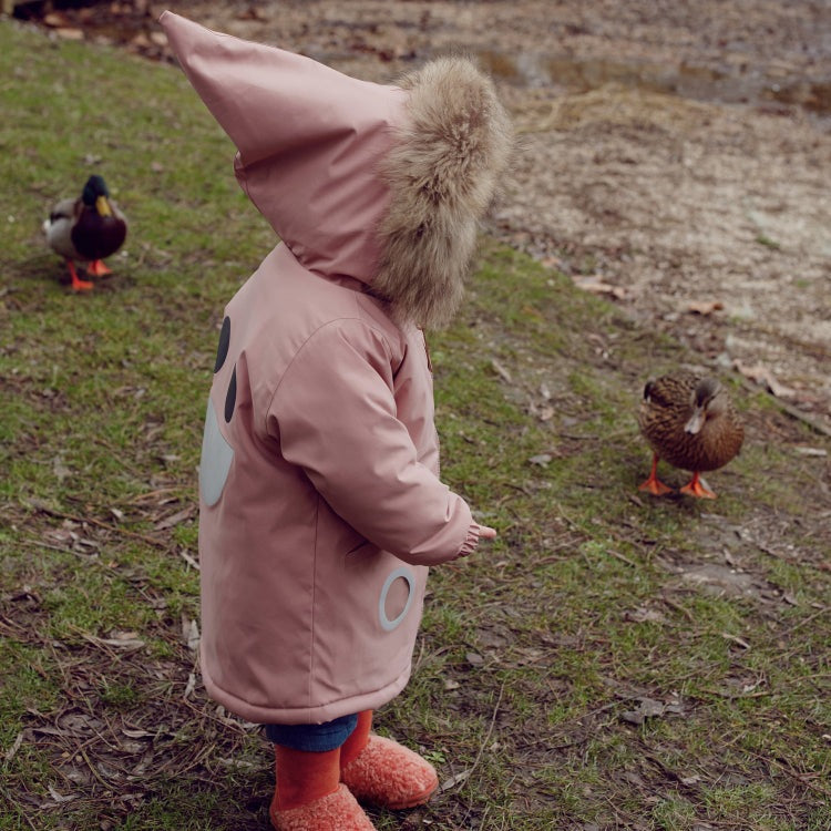 Boxbo Wistiti fleece-lined waterproof & snowproof fur jacket in dusty rose pink; toddler walks outdoors in a fur-hood.