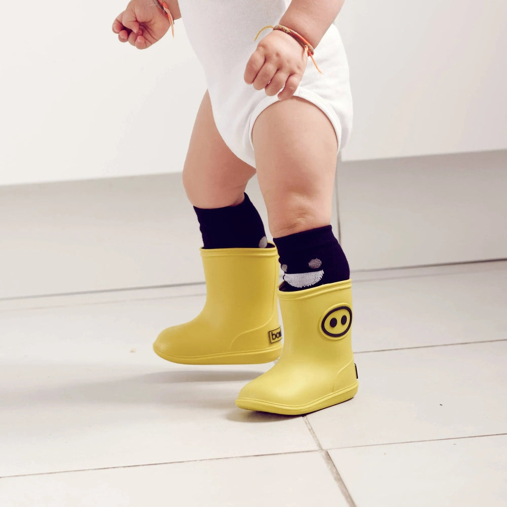 Boxbo Wistiti High Sock Black for infants with grey cloud pattern, shown with yellow rain boots