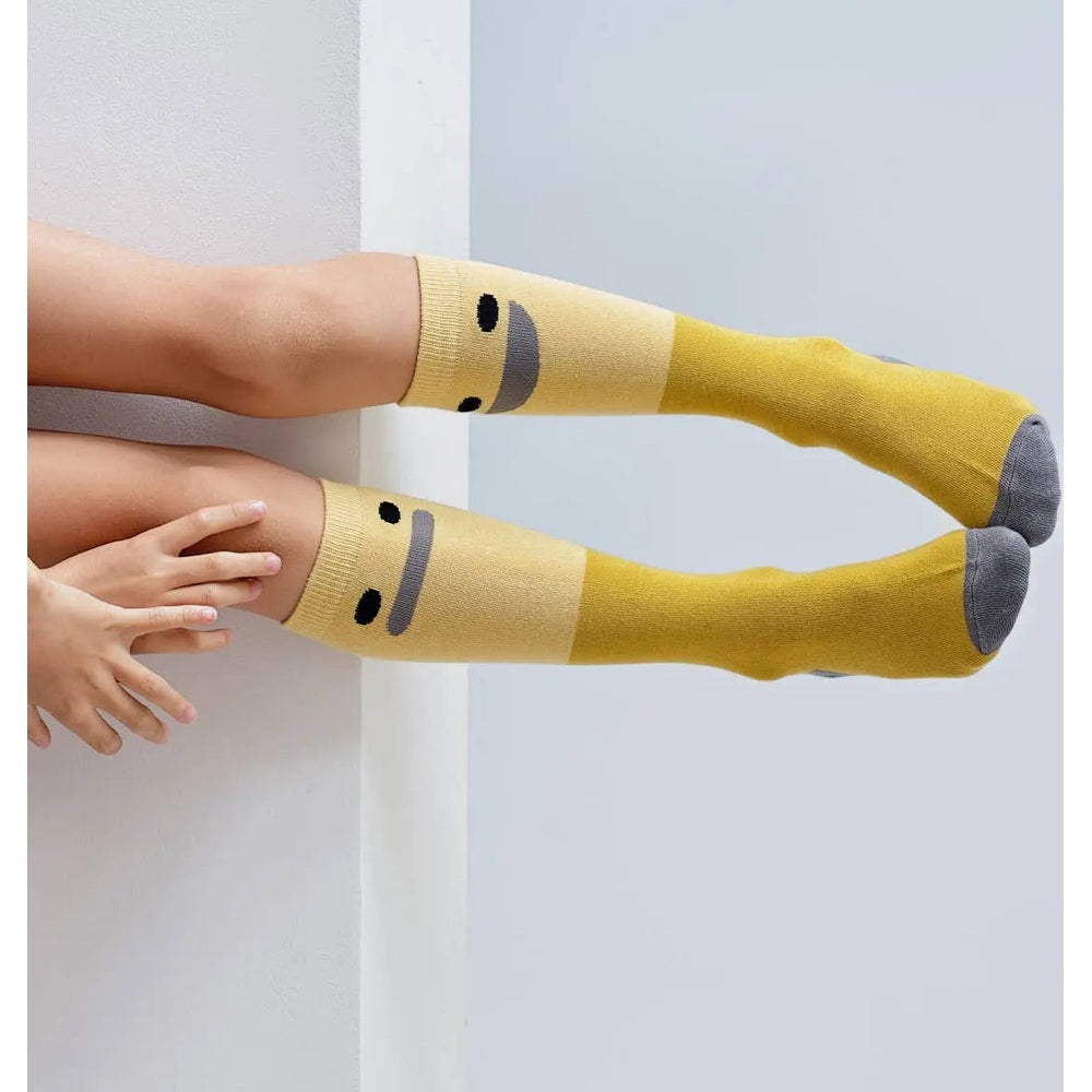 Boxbo Wistiti High Sock Yellow, two baby socks with grey toes and smiling face accents.