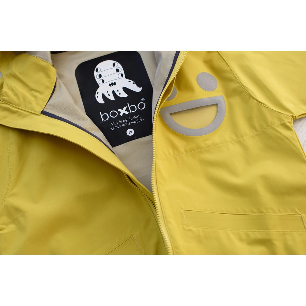 Boxbo Wistiti Windbreaker Rain Jacket Yellow, zipper opened to reveal chest logo emblem on bright yellow rain coat.