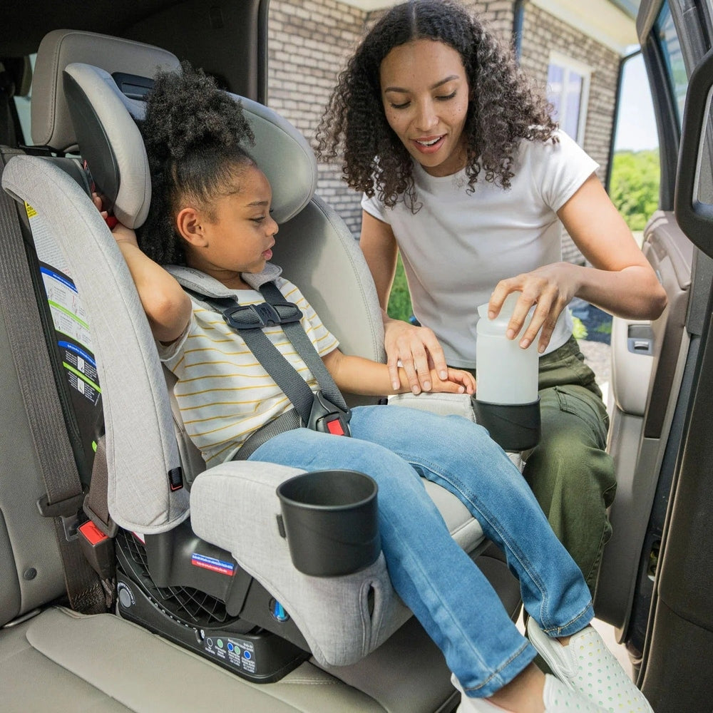 Britax One4Life Slim ClickTight All-in-One Car Seat, gray, child buckled in as caregiver places a bottle in the cup holder.