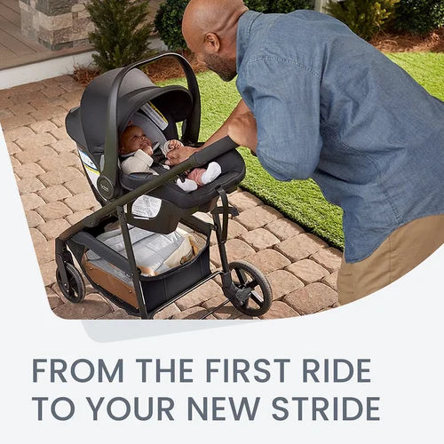 Britax Willow Brook Travel System stroller with infant car seat; dad pushes it down brick path for a smooth, secure ride.