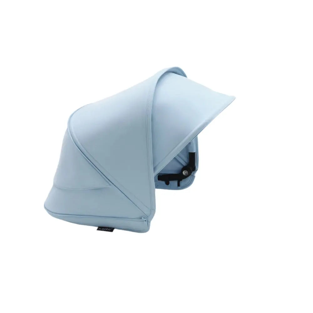 Bugaboo Dragonfly sun canopy in light blue fabric mounted on stroller, extending to shade the child.