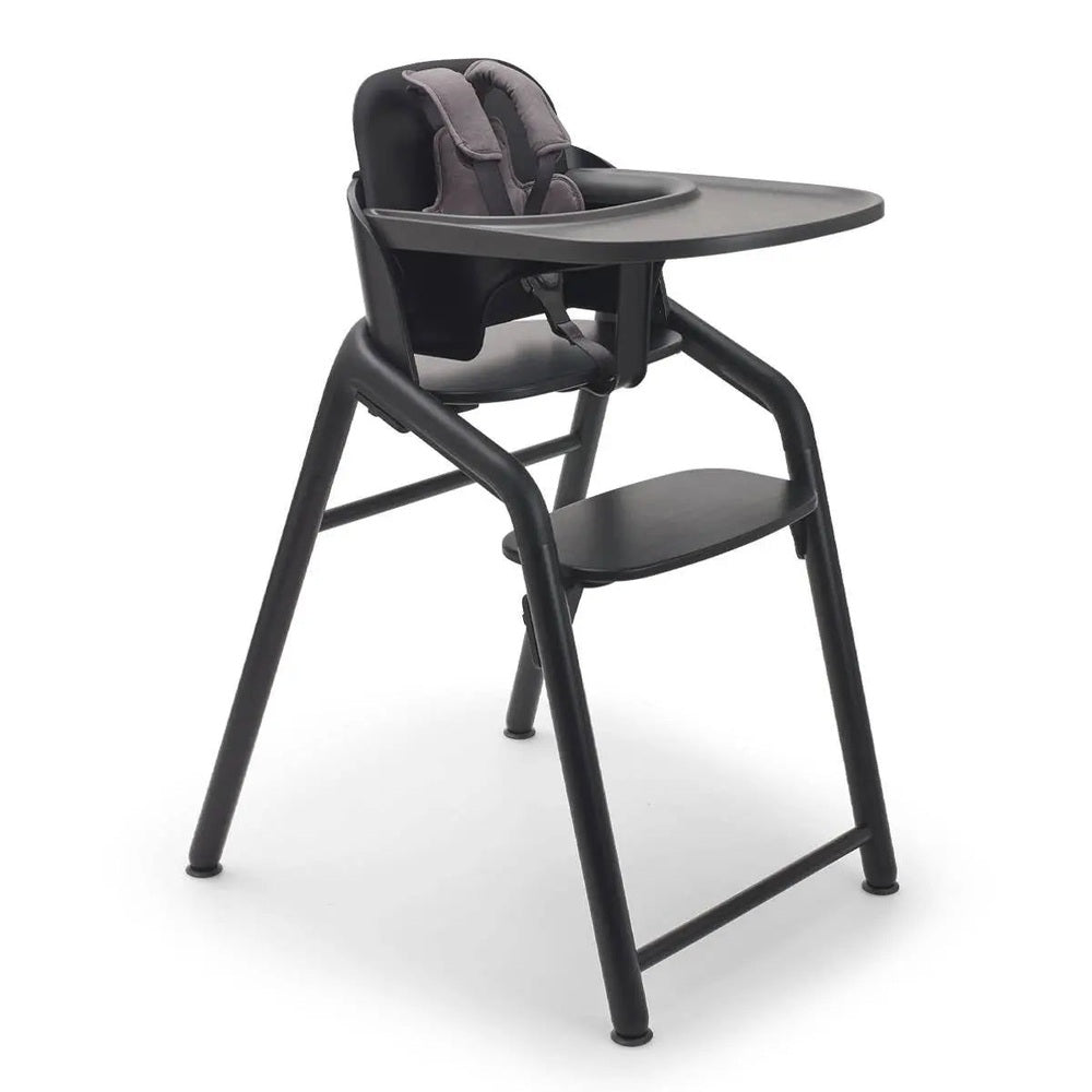 Bugaboo Giraffe Complete High Chair Set with black frame and gray tray, cushioned 5-point harness secured.