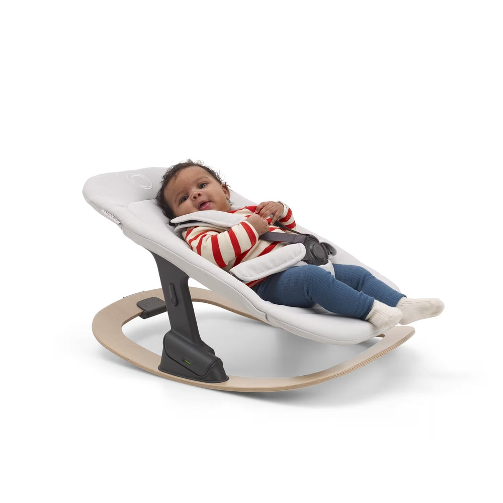 Bugaboo Giraffe Newborn Set in White seat with curved natural wood base and dark gray frame, baby reclined.