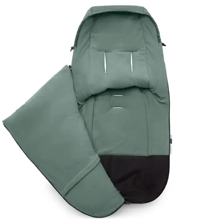 BUGABOO Performance Winter Footmuff in green with black base, opened to cradle a child for stroller use