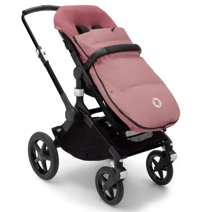Bugaboo Performance Winter Footmuff on a pink stroller, snugly covering the seat with plush lining.