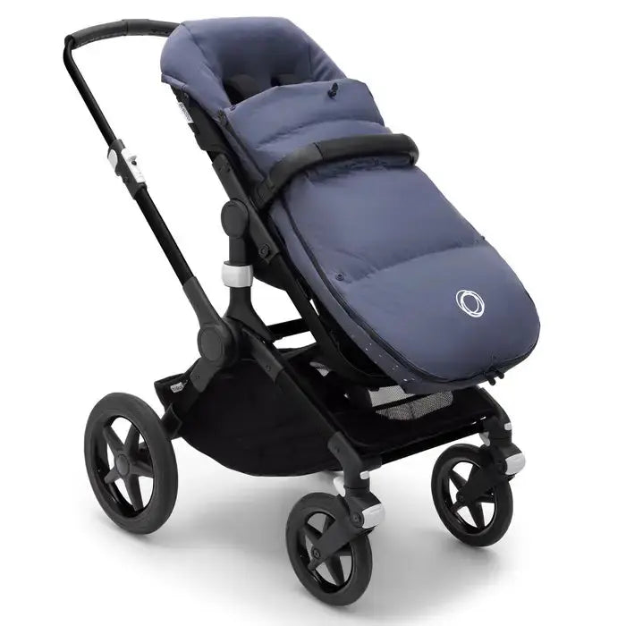 Bugaboo Performance Winter Footmuff in navy, attached to a stroller with padded interior and harness openings.