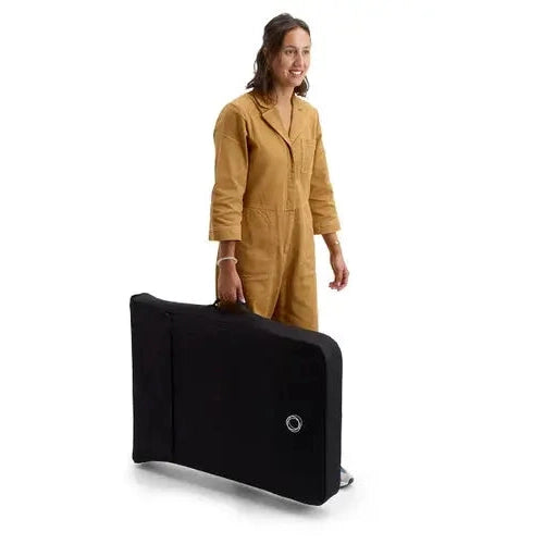 Bugaboo Stardust Playard in black carry case carried by a person, demonstrating portable cozy space.