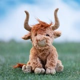 Bukowski Bears Henderson stuffed animal plush Highland cow sits upright on a green field, orange-brown fur.