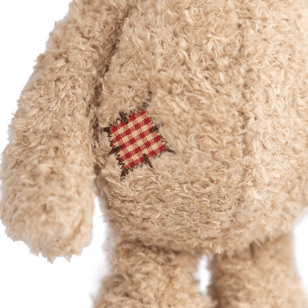 Bukowski Bears Nobody is Perfect stuffed animal, beige fuzzy bear with a red plaid patch sewn on its chest.