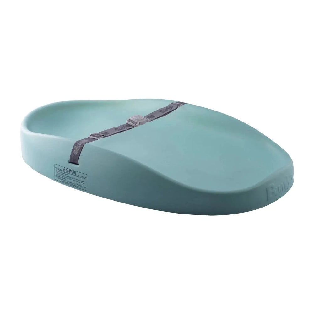 Bumbo Changing Pad in teal with a gray safety strap shown across the pad for secure, comfortable diaper changes.
