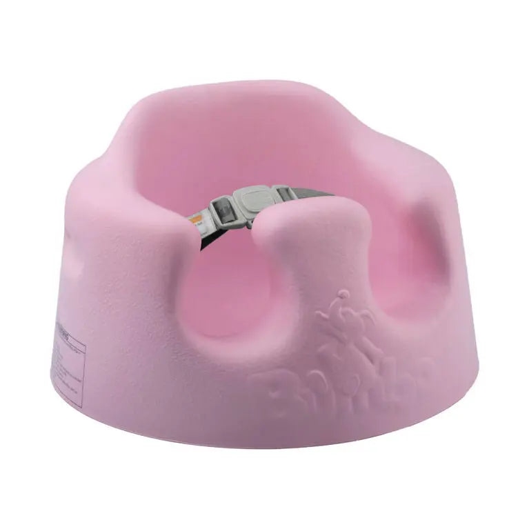 Bumbo Floor Seat pink foam baby chair with built-in safety belt fastened.