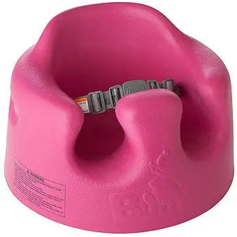 Bumbo Floor Seat pink, molded infant booster chair with gray safety belt ready to support a child sitting upright.