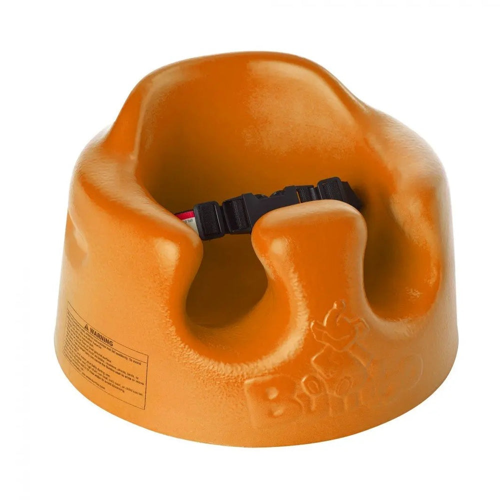 Bumbo Floor Seat, orange plastic baby booster with adjustable safety strap shown securing a snug fit.