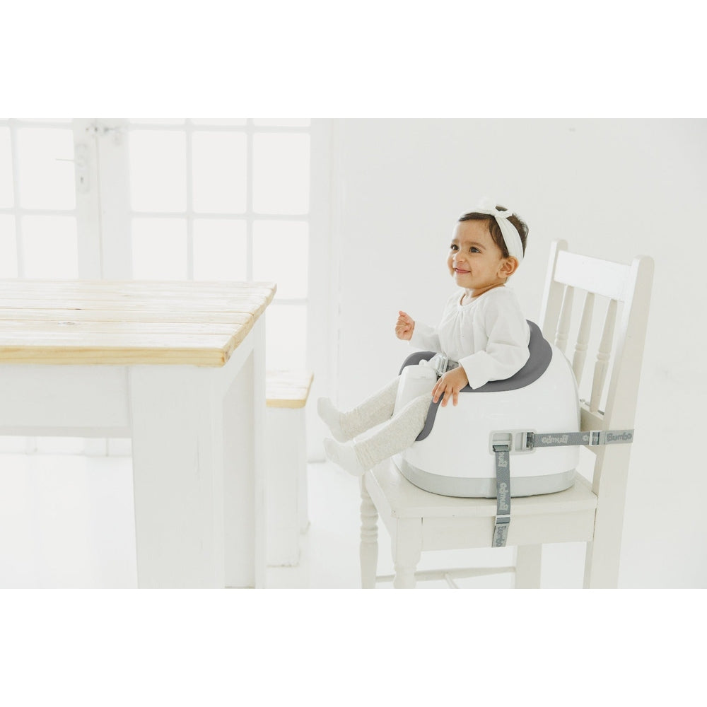 BUMBO Multi Seat Cool Grey booster seat for toddlers, shown on a white chair with a smiling baby.