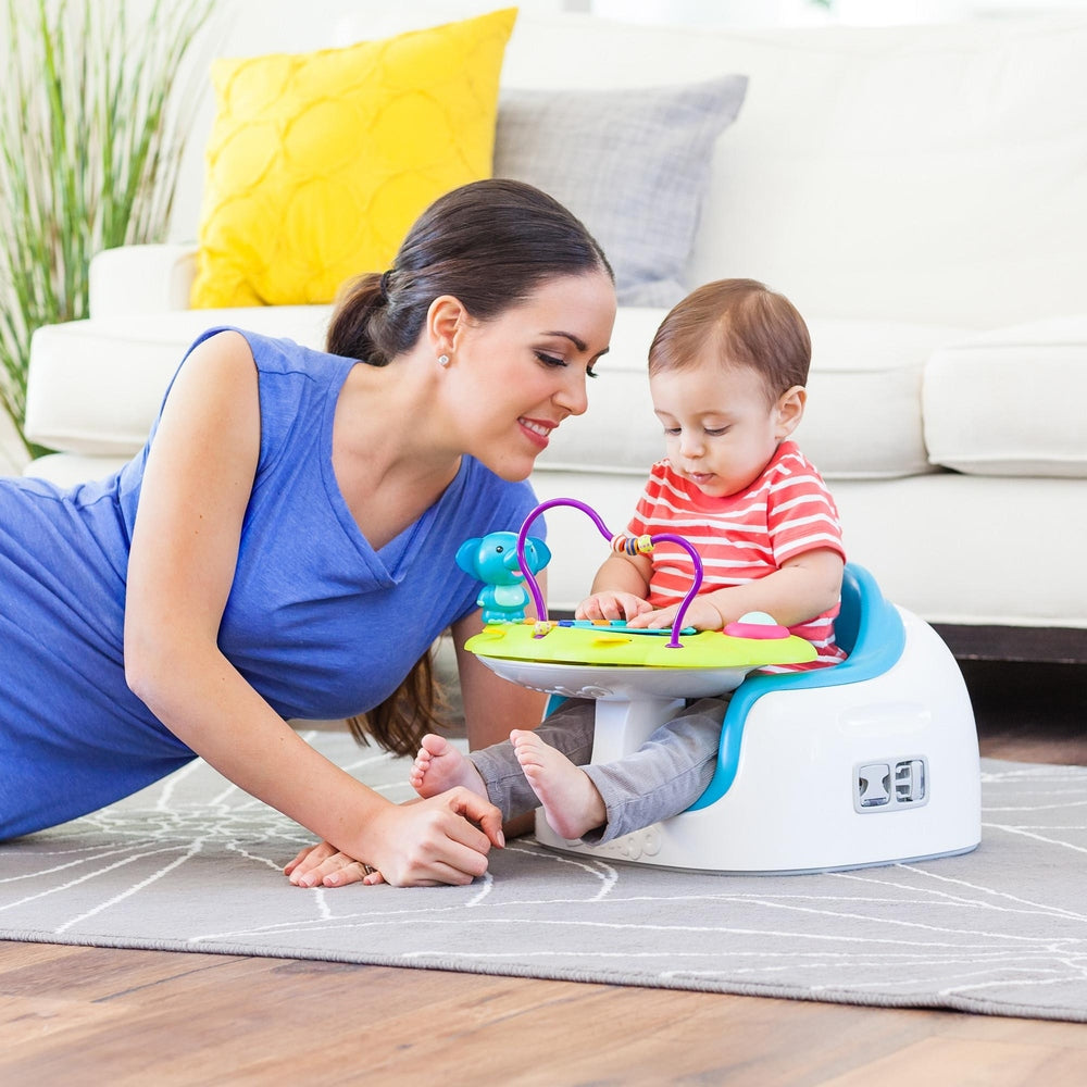 BUMBO Playtop Safari baby activity seat with lime-green tray and purple arches; mom plays with baby.