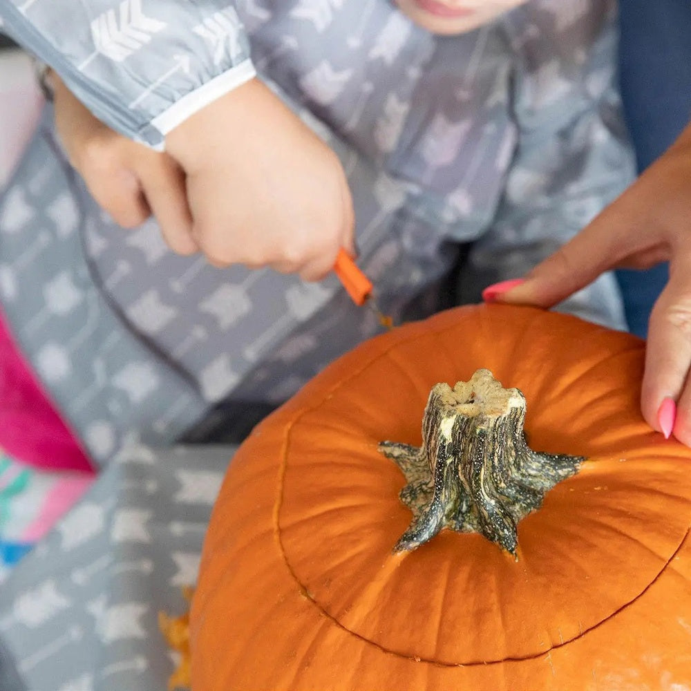 BUMKINS Long Sleeved Smock Bib; kid carves a pumpkin, keeping clothes clean.