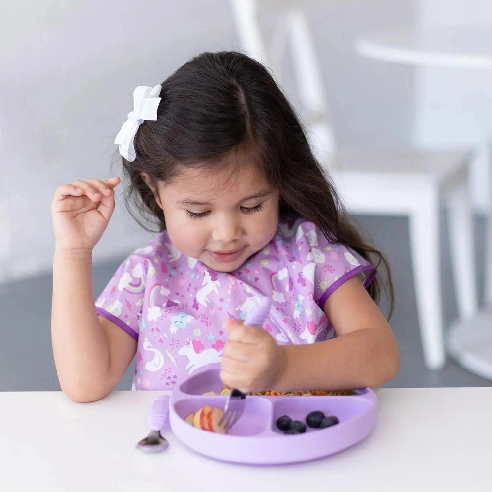 BUMKINS Silicone Grip Dish lavender divided plate; toddler uses fork to scoop fruit, blueberries in one compartment