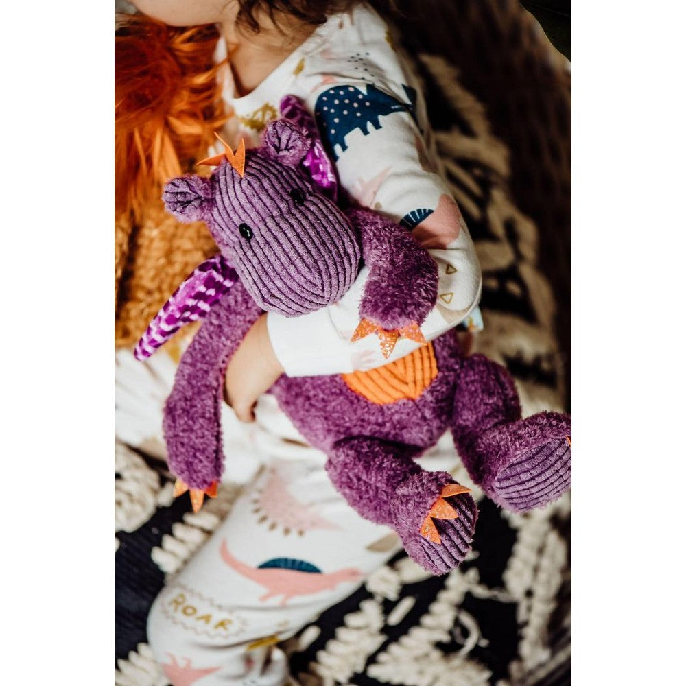 Dunkin the Dragon plush by Bunnies By The Bay; purple dragon stuffed toy with orange accents held by child in patterned pajamas