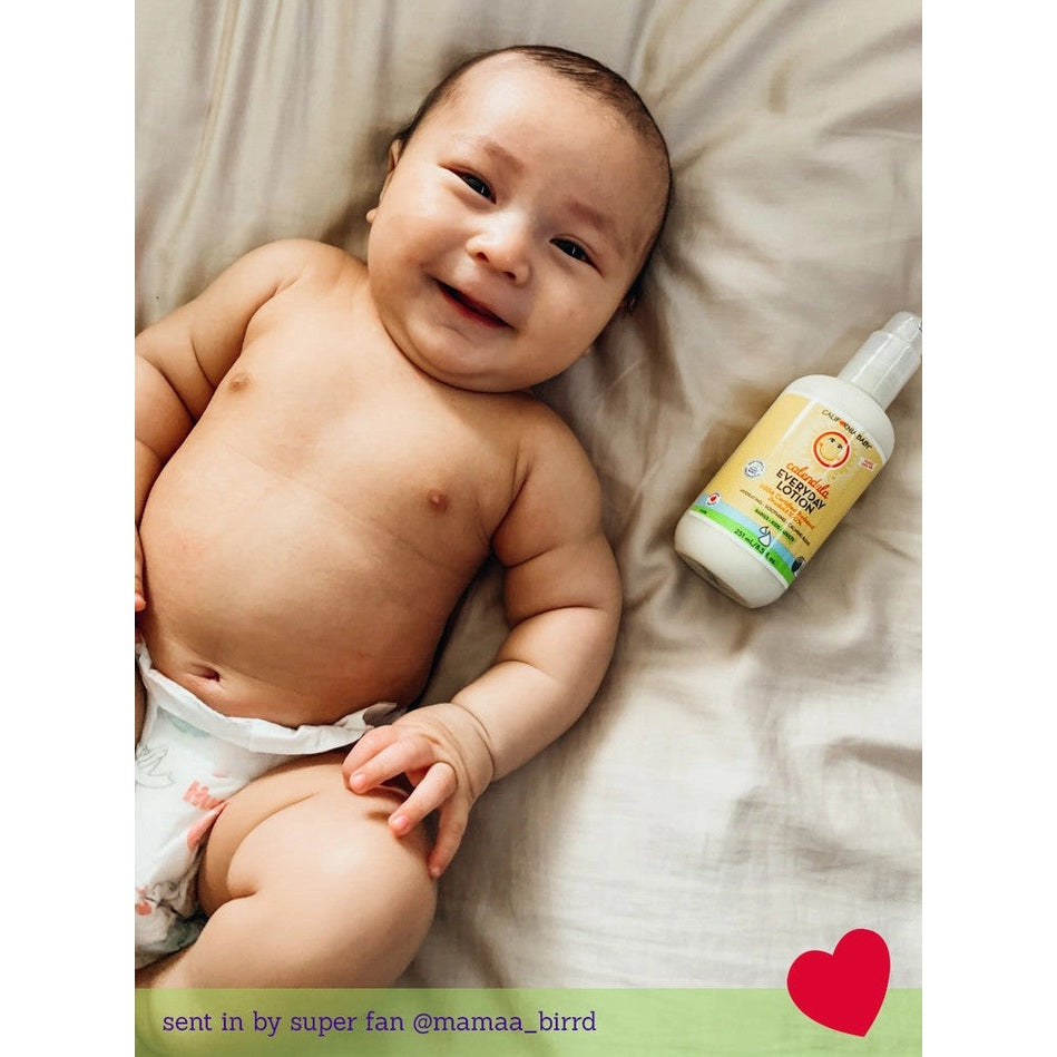 California Baby Calendula Everyday Lotion bottle beside a smiling baby on a bed; CALIFORNIA BABY brand