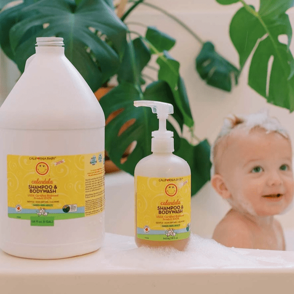 California Baby Calendula Shampoo & Bodywash; two yellow-labeled bottles beside a smiling baby in a foamy bath.