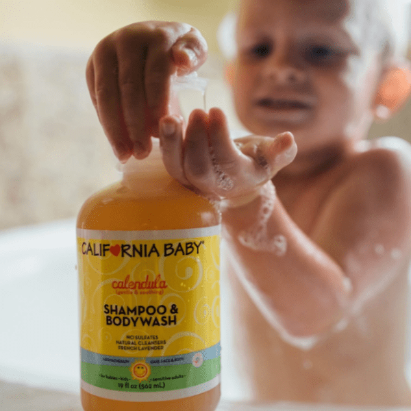 California Baby Calendula Shampoo & Bodywash bottle as a baby presses the pump during bath.