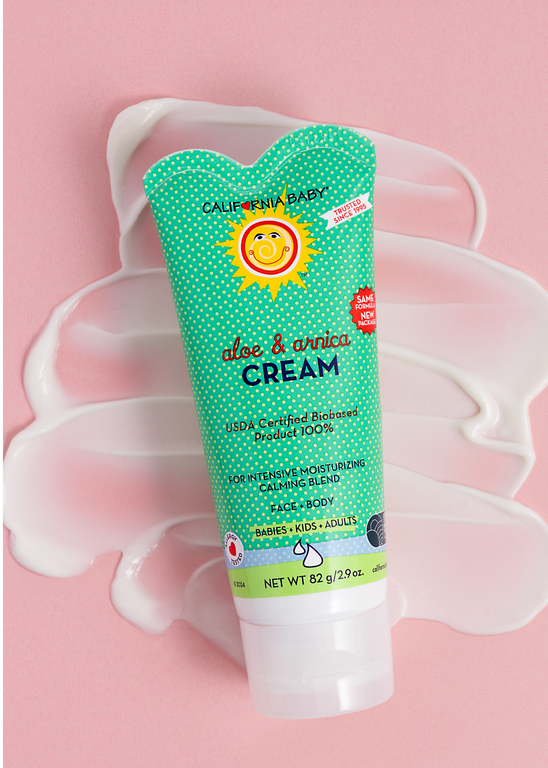 California Baby Aloe & Arnica Cream tube on a pink cream-texture background
