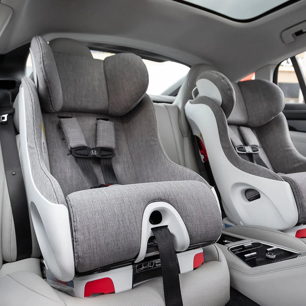 CLEK Foonf convertible car seats in gray fabric, featuring head support and five-point harnesses, installed side-by-side in a vehicle.