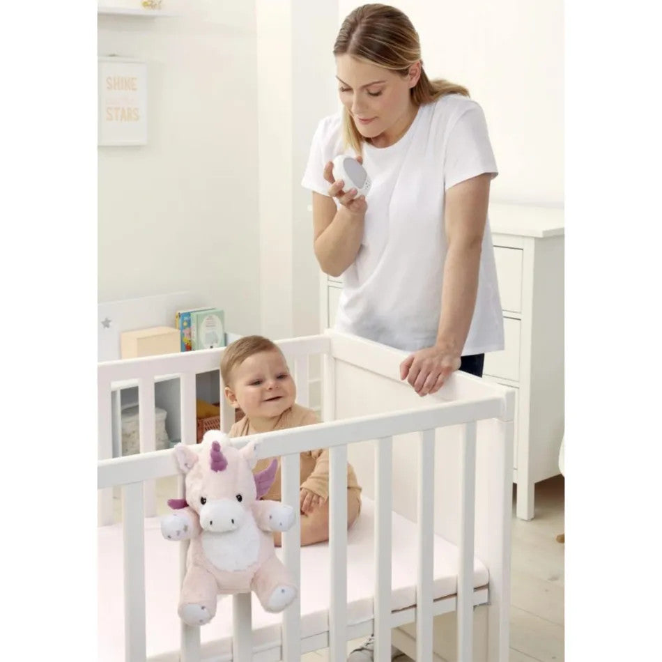 Cloud B Love Light Lily the Unicorn plush toy with pink accents hanging on a white crib