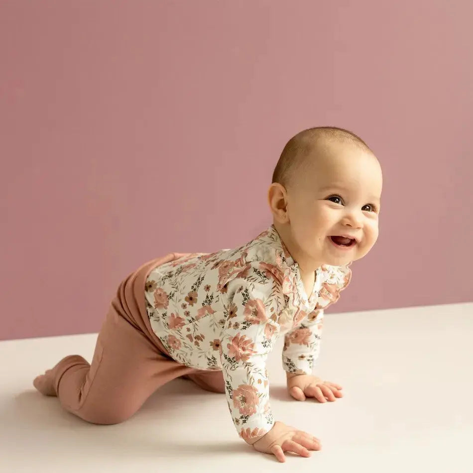 COCCOLI Coccoli Infant Floral Cotton TENCEL™ Modal Romper in pink floral print, baby crawling and smiling.