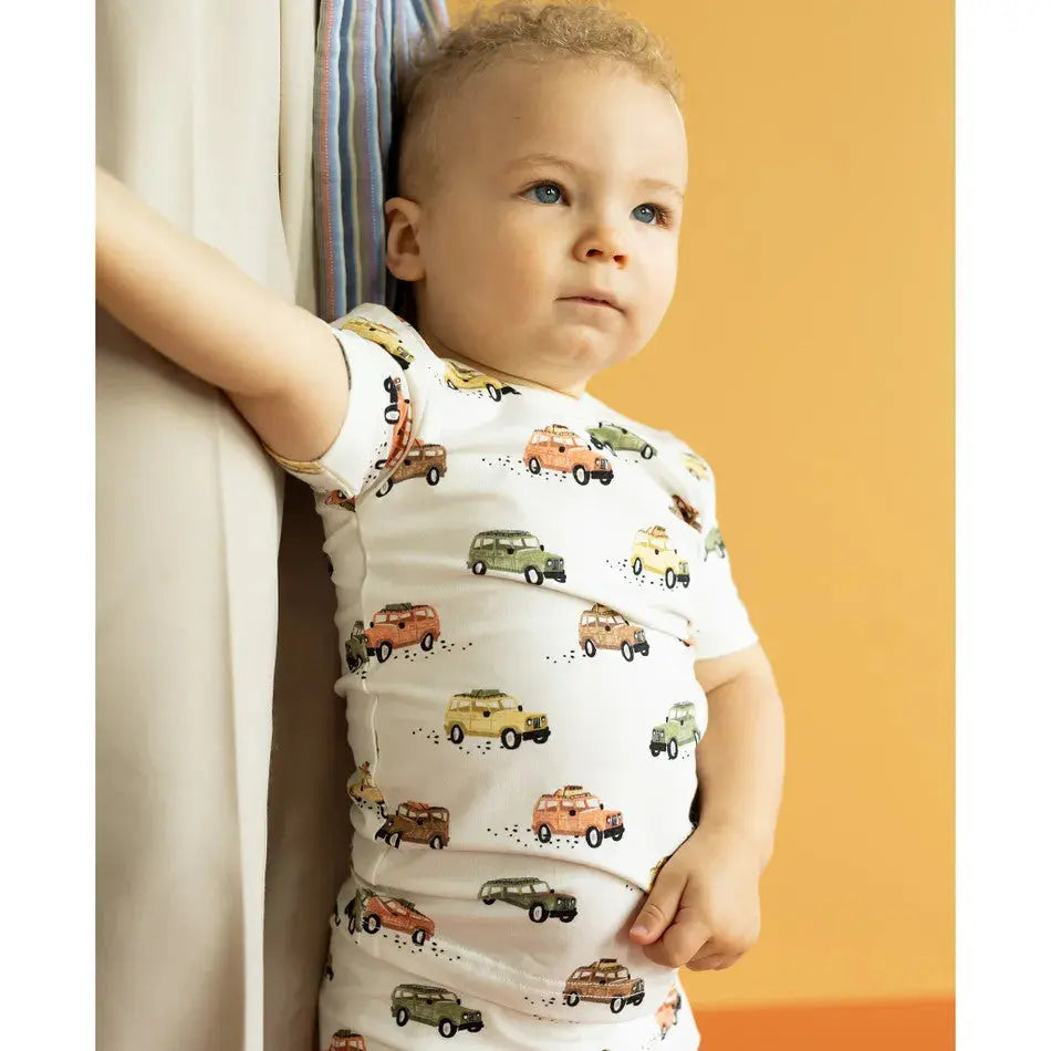 Coccoli Kid Jeeps Cotton TENCEL Modal short pajamas; white with colorful jeep prints, toddler standing by a window.