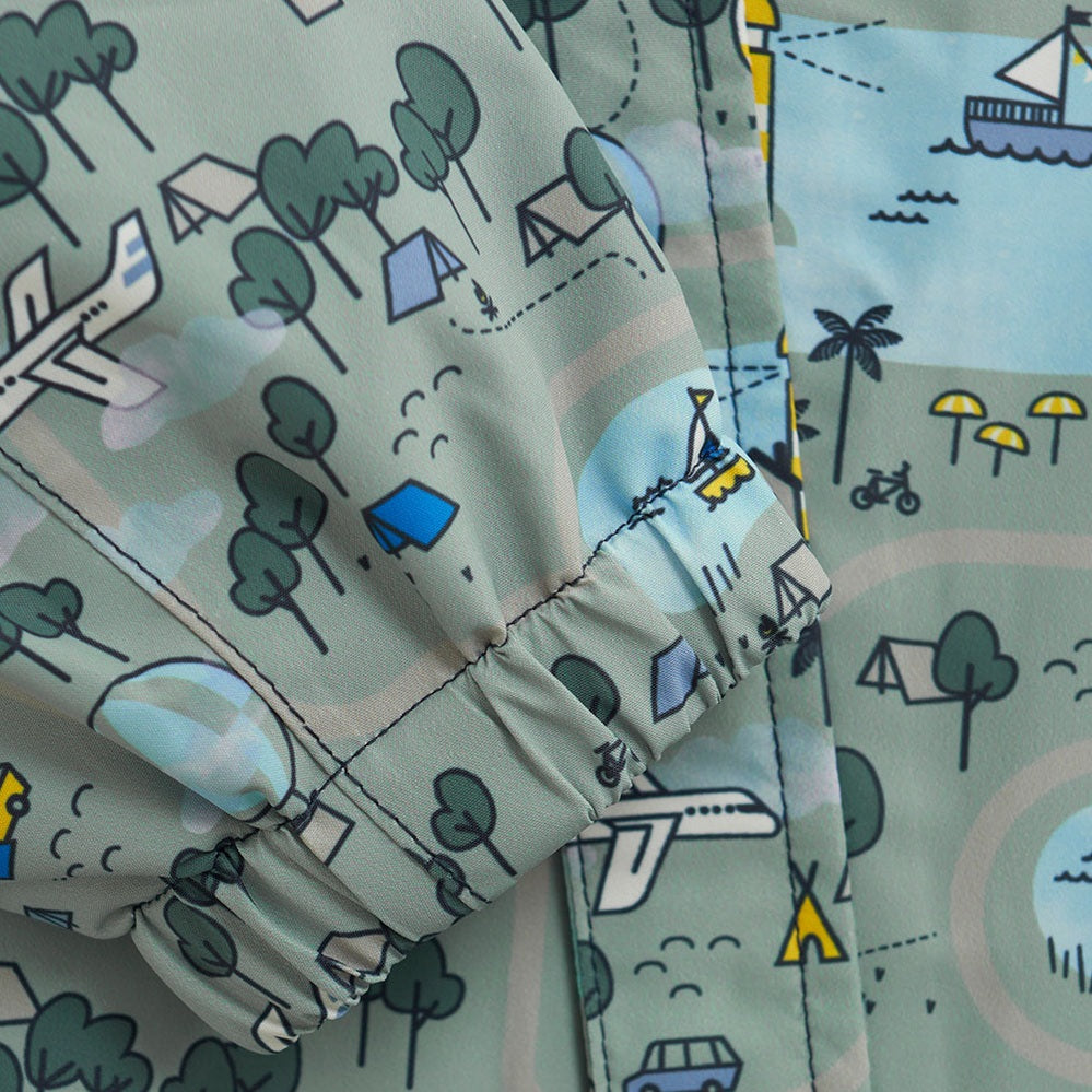 Color Kids Girls Shell Suit Dusty Green, elastic cuffs, worn by a child in light rainwear with a map-print pattern.