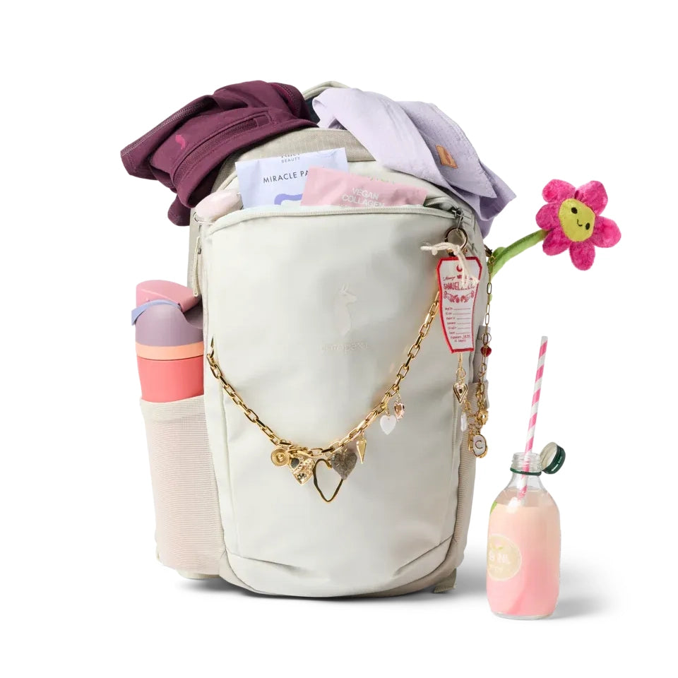 Cotopaxi Allpa 18L Daypack in Cream with gold charm chain