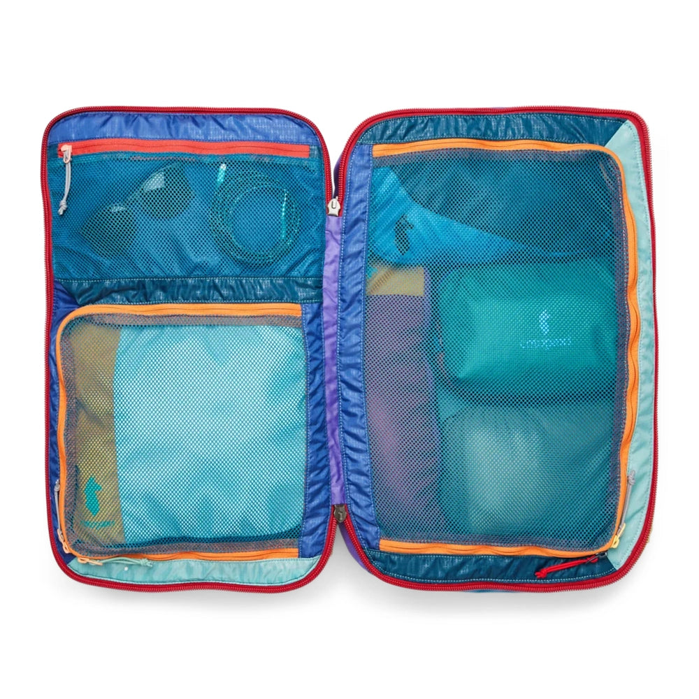 Cotopaxi Allpa 35L Travel Pack in teal interior with orange zippers and purple trim, open dual-mesh pockets.