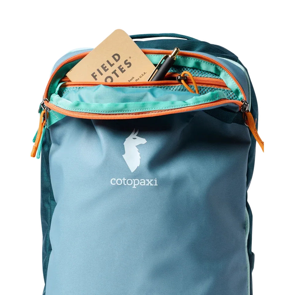 Cotopaxi Allpa Mini 20L Travel Pack in Teal with orange zippers, front view with top pocket open.