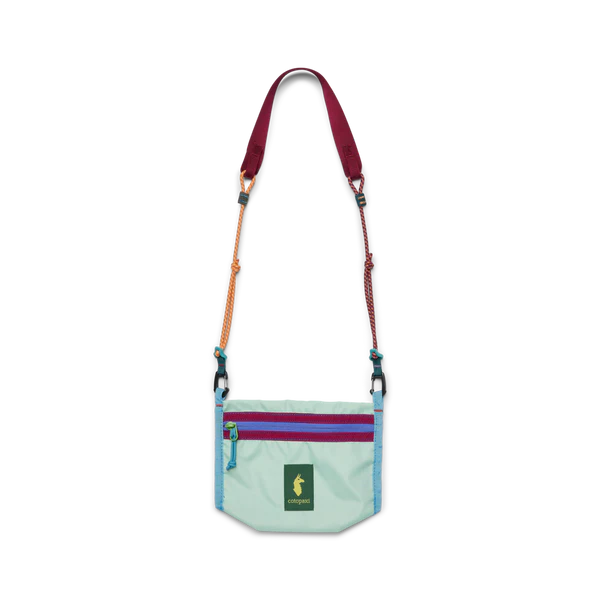 Cotopaxi Lista 2L Crossbody Bag in Mint with purple zip panel and two-tone orange/pink adjustable straps.