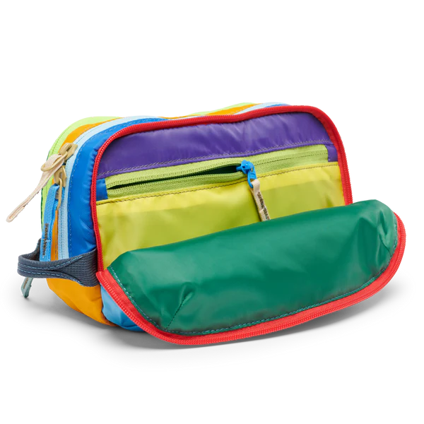 Cotopaxi Nido Accessory Bag in rainbow color-block with green front pocket and red zipper trim.